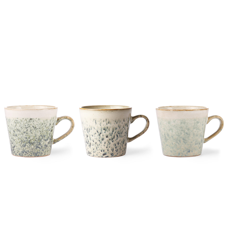 Three ceramic mugs with speckled design and brown rims on a white background