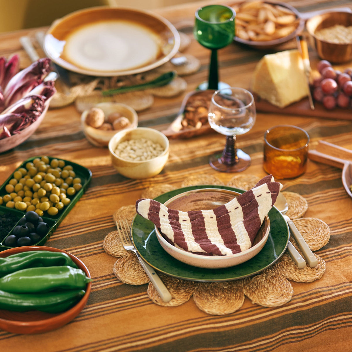 green plate, olive green fork and knife and striped napkin