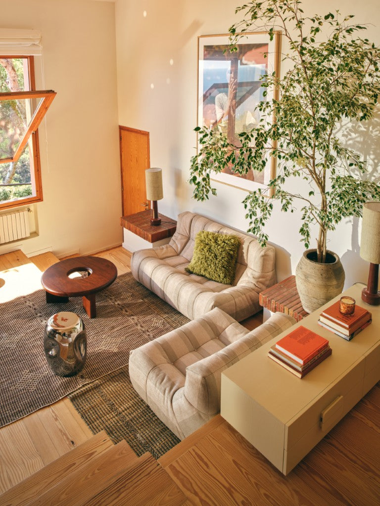 Living room with beige sofa, coffee table, and decorative items.