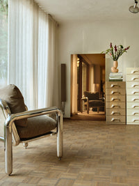 chrome occasional chair, large mirror and mocha brown chest of drawers