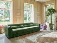 pink square block accent table with velvet green sofa