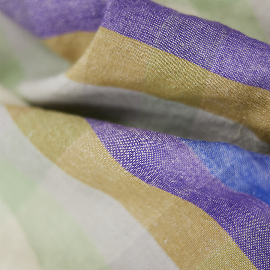 Close-up of fabric with purple, gold, and white stripes.