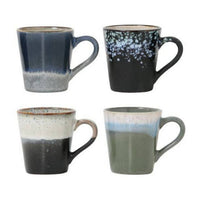 Set of four ceramic mugs with gradient designs on a white background
