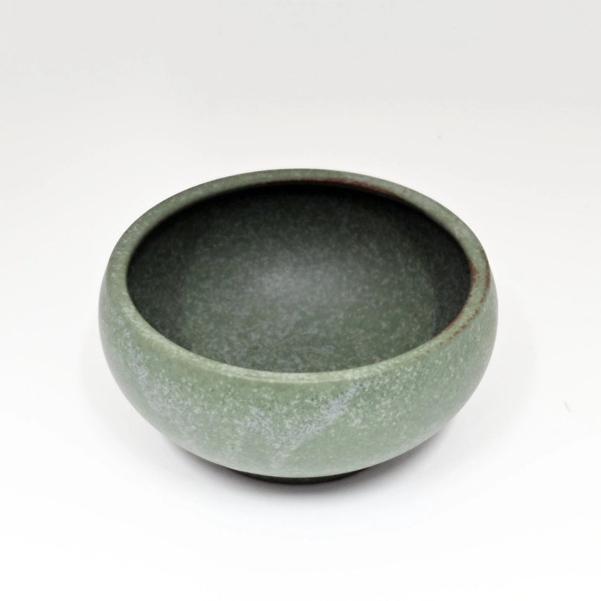 Green ceramic bowl on a white background