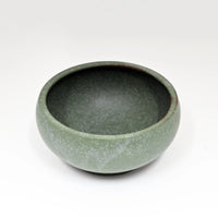 Green ceramic bowl on a white background