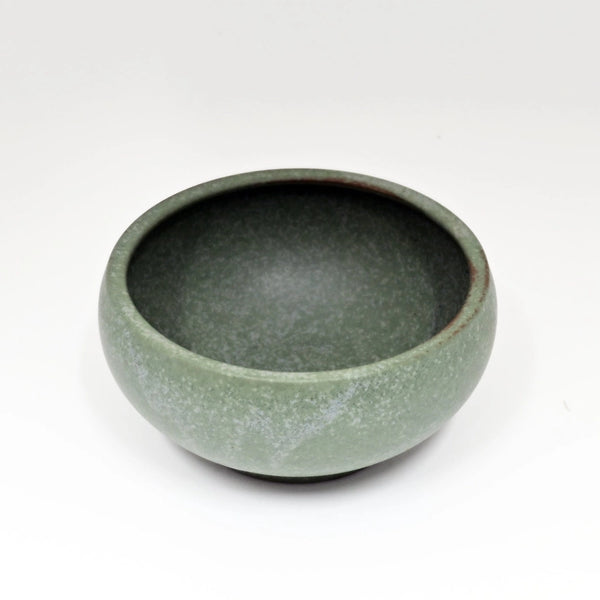 Green ceramic bowl on a white background