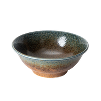 Ceramic bowl with speckled glaze on a white background