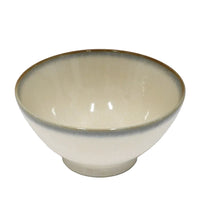 Beige ceramic bowl with brown rim on a white background