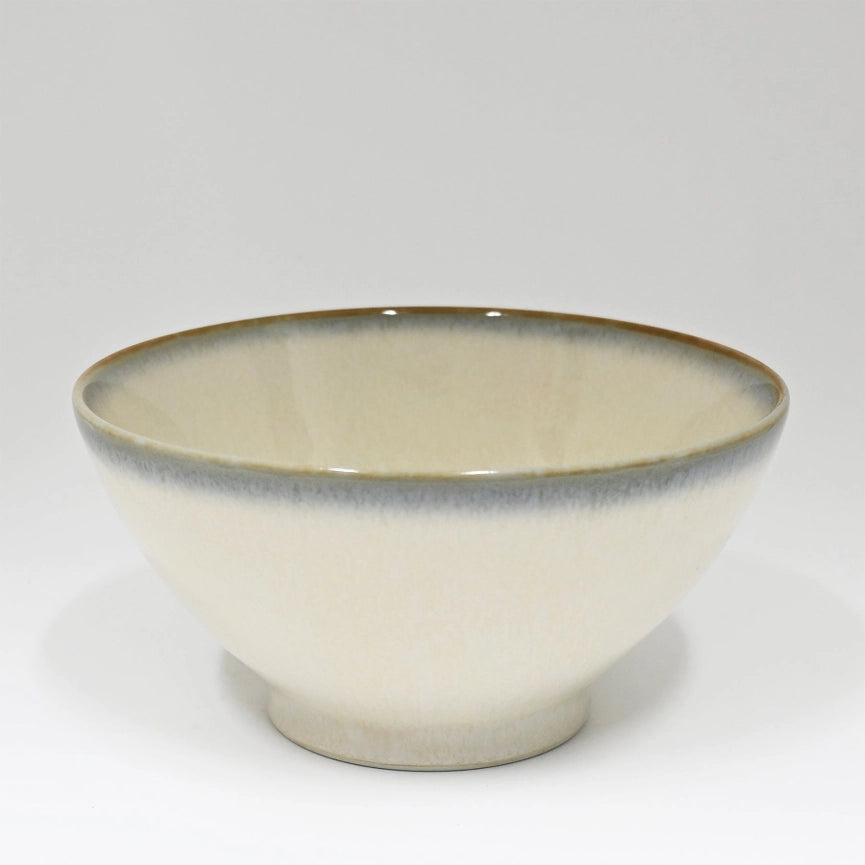 Ceramic bowl with a beige interior and brown rim on a white background