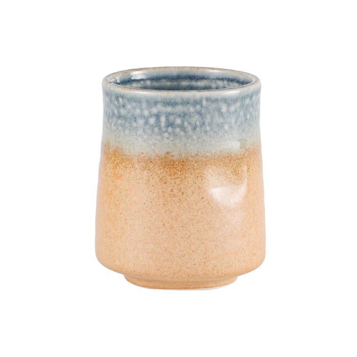 Ceramic cup with blue top and beige bottom on a white background