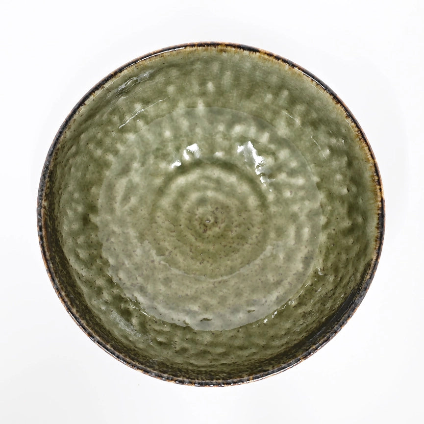Green ceramic bowl with textured surface on a white background