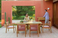 Two people sitting at an outdoor dining table with chairs on a patio.