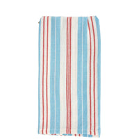 Striped towel with blue, red, and white pattern on a cardboard backing