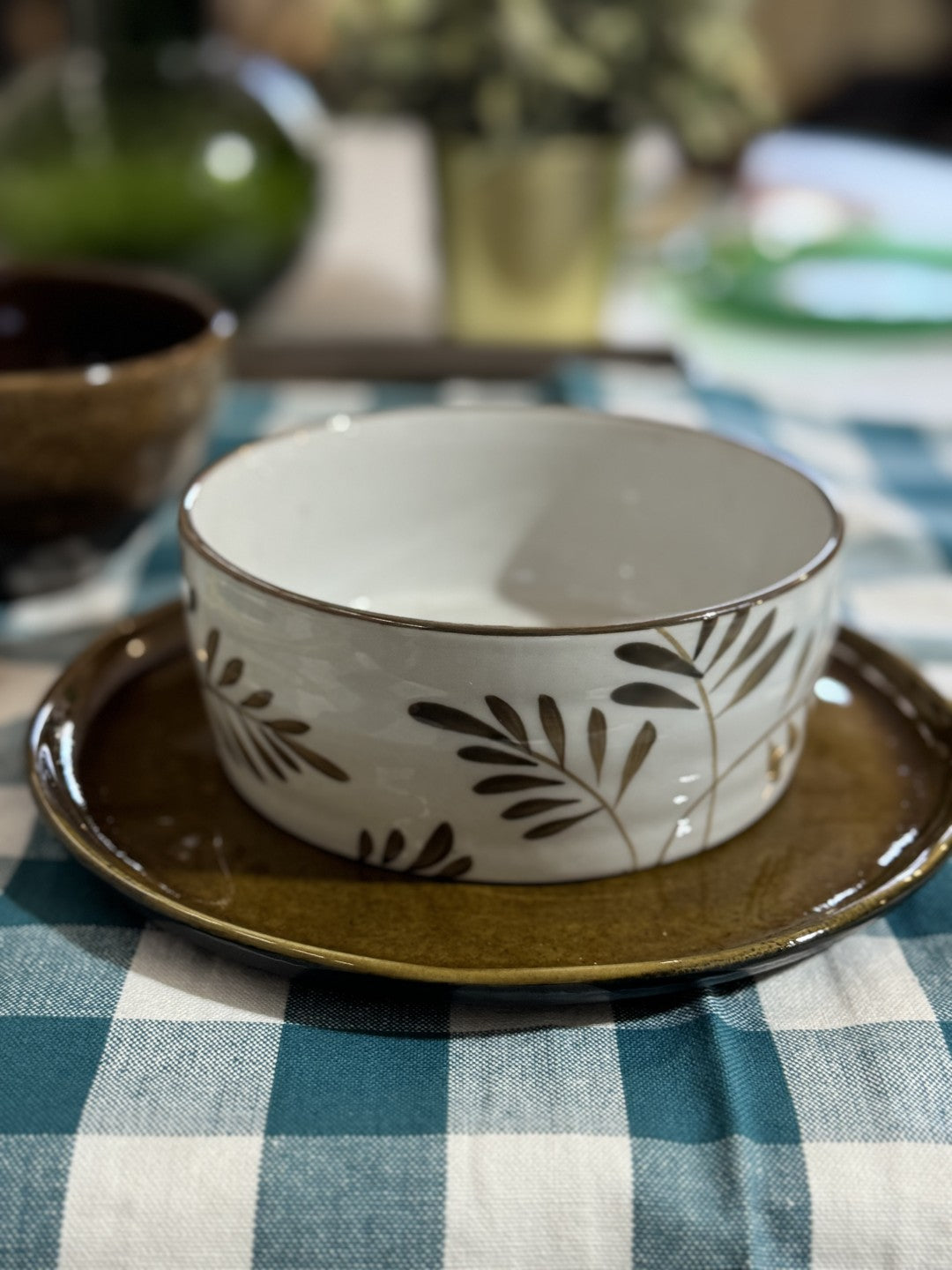 Ceramic bowl with leaf pattern on a checkered tablecloth