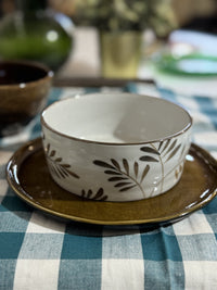 Ceramic bowl with leaf pattern on a checkered tablecloth