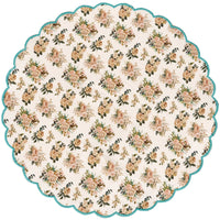 Round floral patterned placemat with scalloped edge on a white background