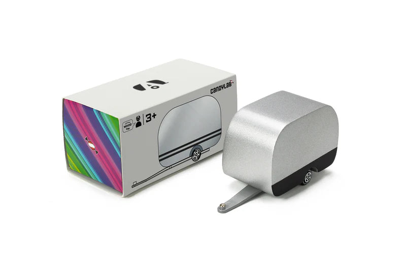 Silver and black wooden airstream camper with colorful packaging on a white background