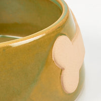 Close-up of a ceramic dog bowl with a bone-shaped detail on a white background