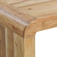 Close-up of a light natural wood table corner showing the thick rounded apron, tabletop grain, and leg joint against a white background.