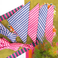 Colorful striped fabric with tassels on a green background
