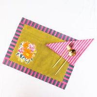 Colorful placemat with floral design and striped edges on a white background