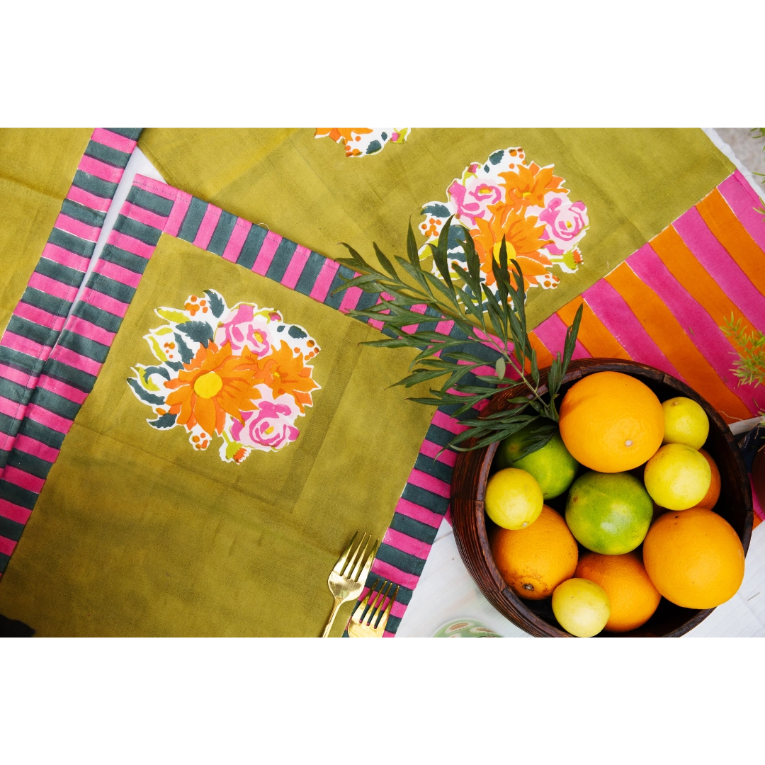 Colorful tablecloth with floral patterns and a bowl of fruits on a white background