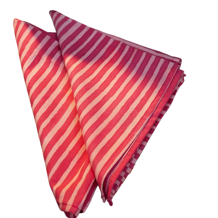 pink and white striped fabric on a table with colorful bowls and floral tablecloth.
