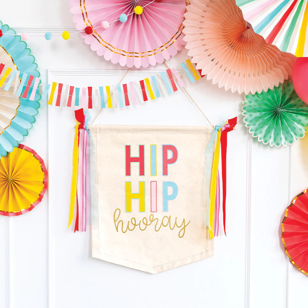 Colorful party decorations with paper fans and a 'Hip Hip Hooray' banner on a white background