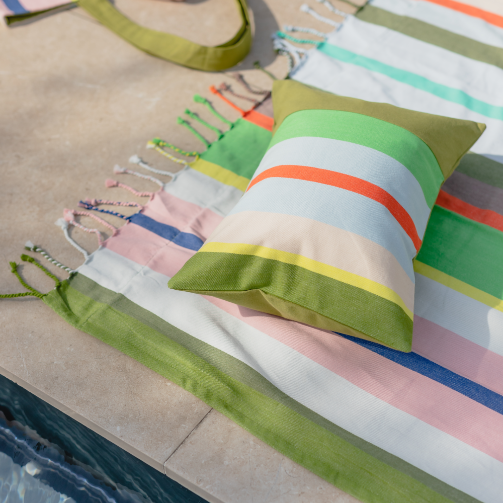 striped inflatable pillow on a blanket on pool deck 