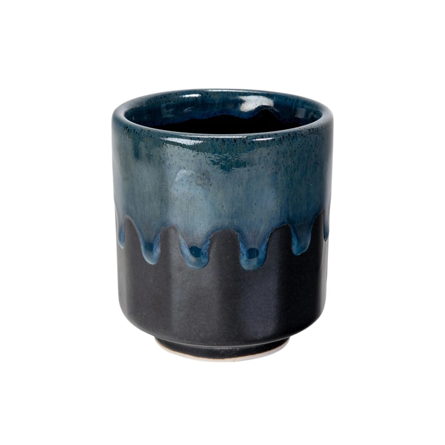 Blue and black ceramic cup with a textured surface on a white background
