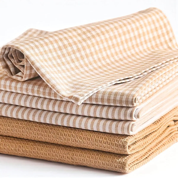 Stack of folded fabric towels in various patterns on a white background