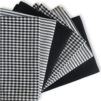 Collection of black and white patterned fabric swatches on a white background