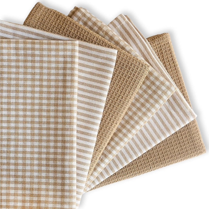 Set of beige and white patterned towels on a white background