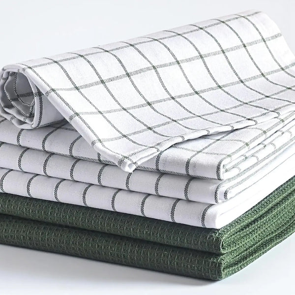 Stack of folded checkered and solid color cloths on a white background