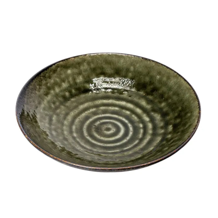 Green ceramic bowl with concentric circle pattern on a white background