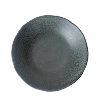Dark gray ceramic plate on a textured white surface
