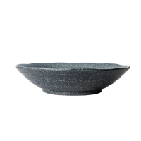 Speckled gray ceramic bowl on a white marble surface