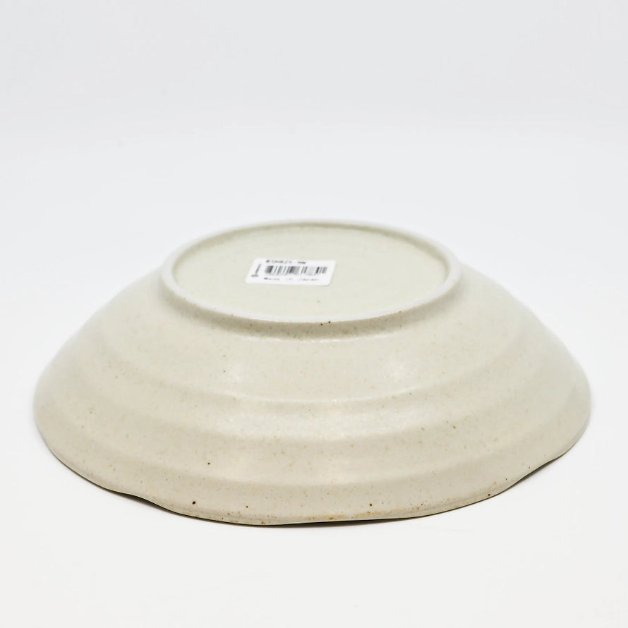 Beige ceramic bowl with a visible brand label on a white background