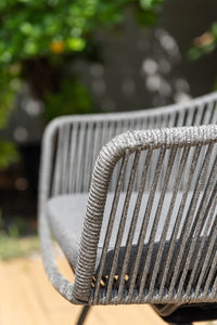 Close-up of a gray chair with a blurred garden background