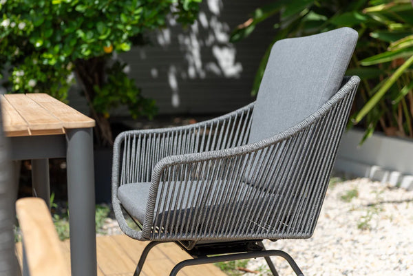 Gray outdoor chair with a wooden table in a garden setting