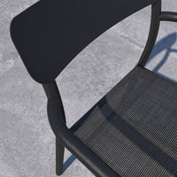 Black metal chair with mesh seat on a concrete surface