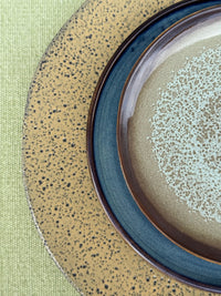 Close-up of ceramic plates with textured surfaces on a green background