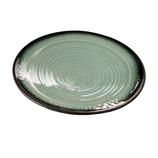Green ceramic plate with concentric circle pattern on a white background