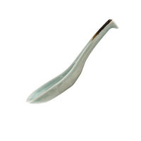White ceramic spoon with brown accent on a white background