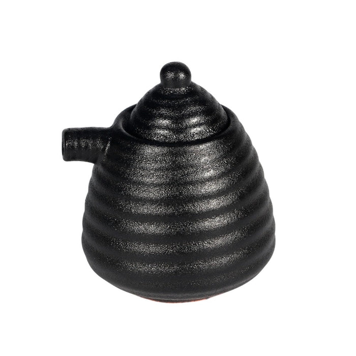 Black ceramic sauce dispenser with a ribbed design on a white background