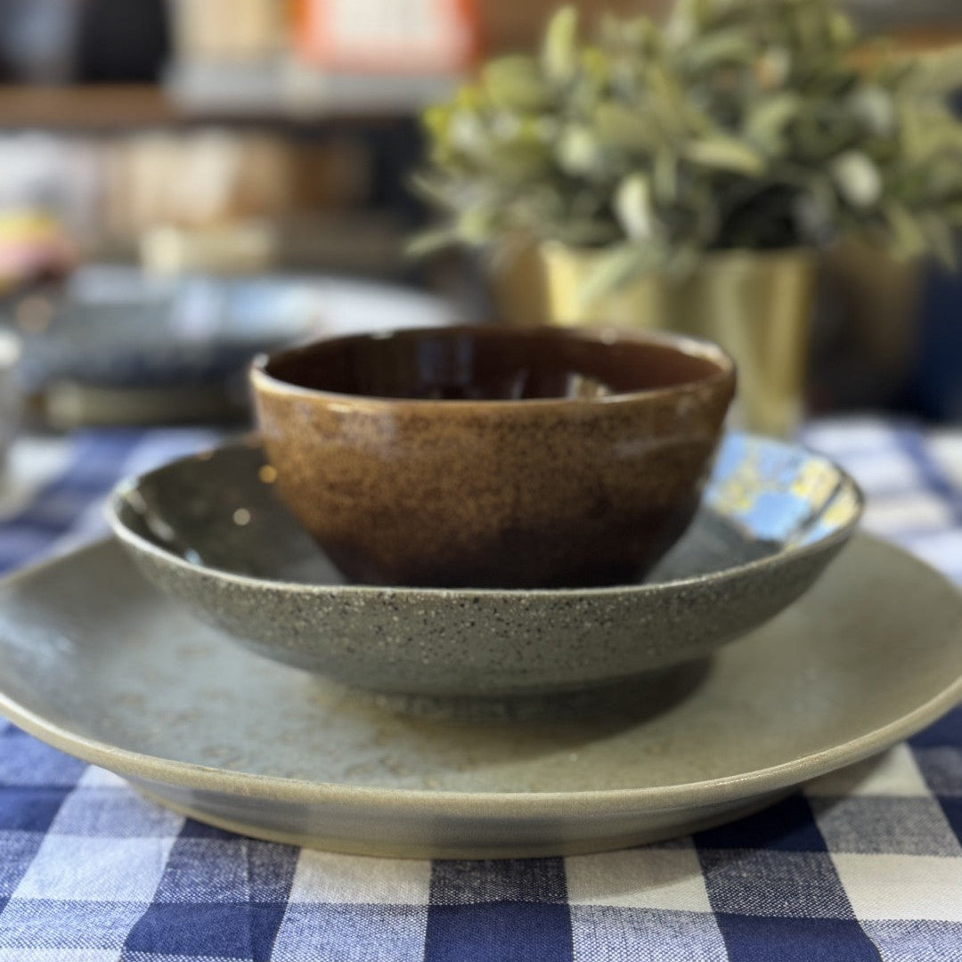 Ceramic bowls on a checkered tablecloth with a blurred background