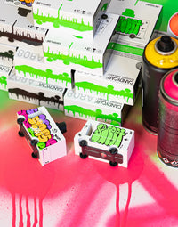 Small wooden design car with colorful designs on a red and pink background 