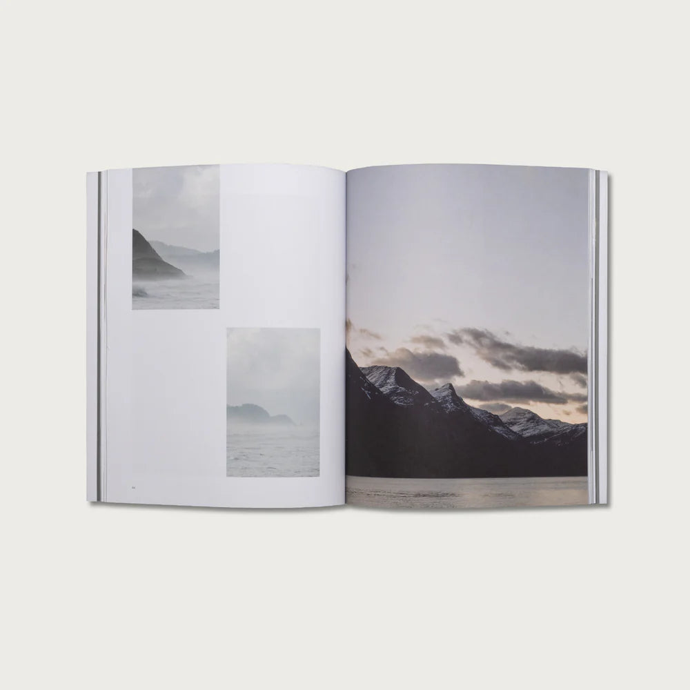 Open book showing pages with mountain landscape images on a white background