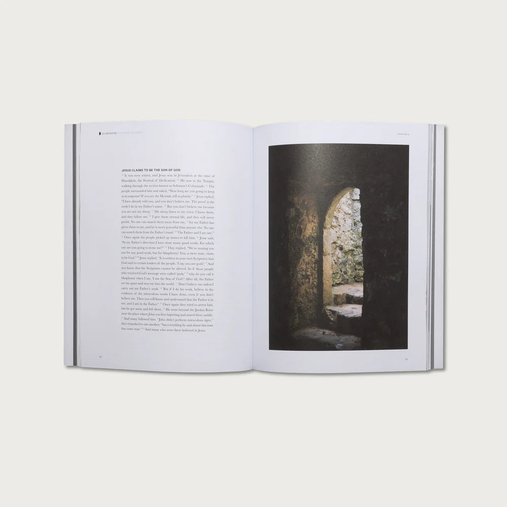 Open book with text on one page and a photograph of a stone archway on the other, on a white background.