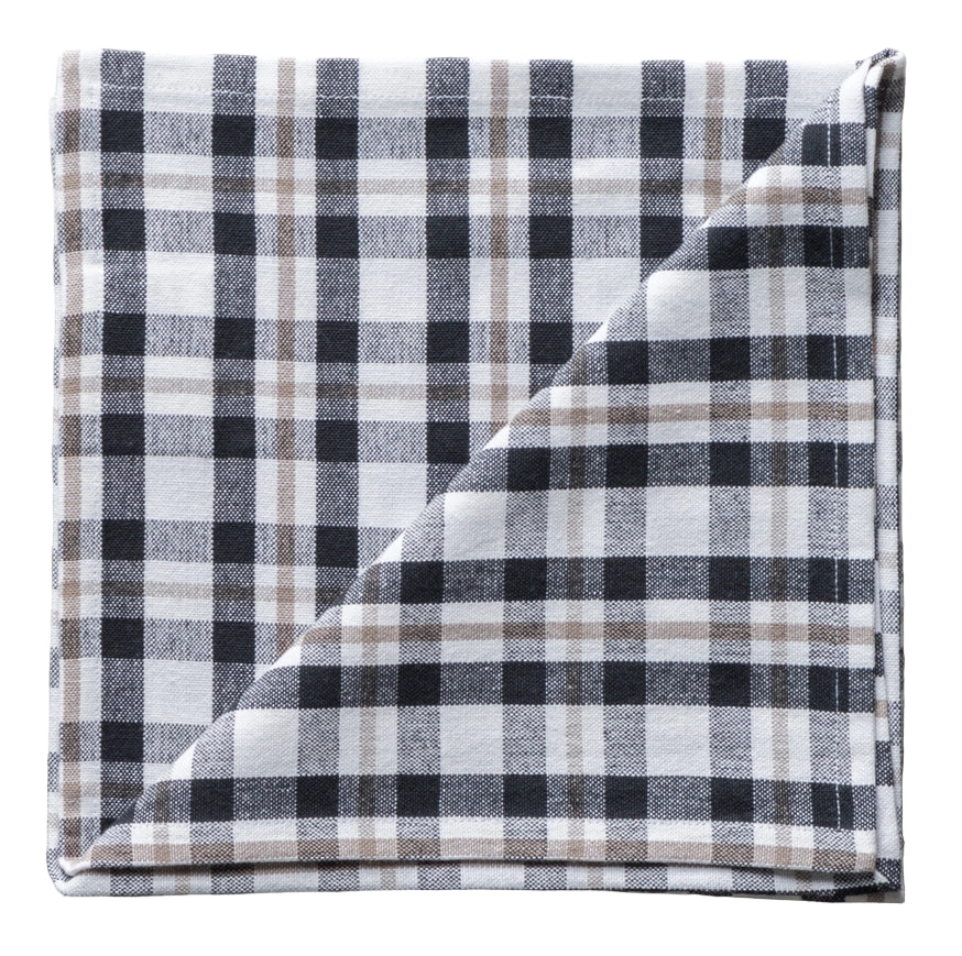 Folded plaid fabric napkin with black, white, and gray pattern on a neutral background